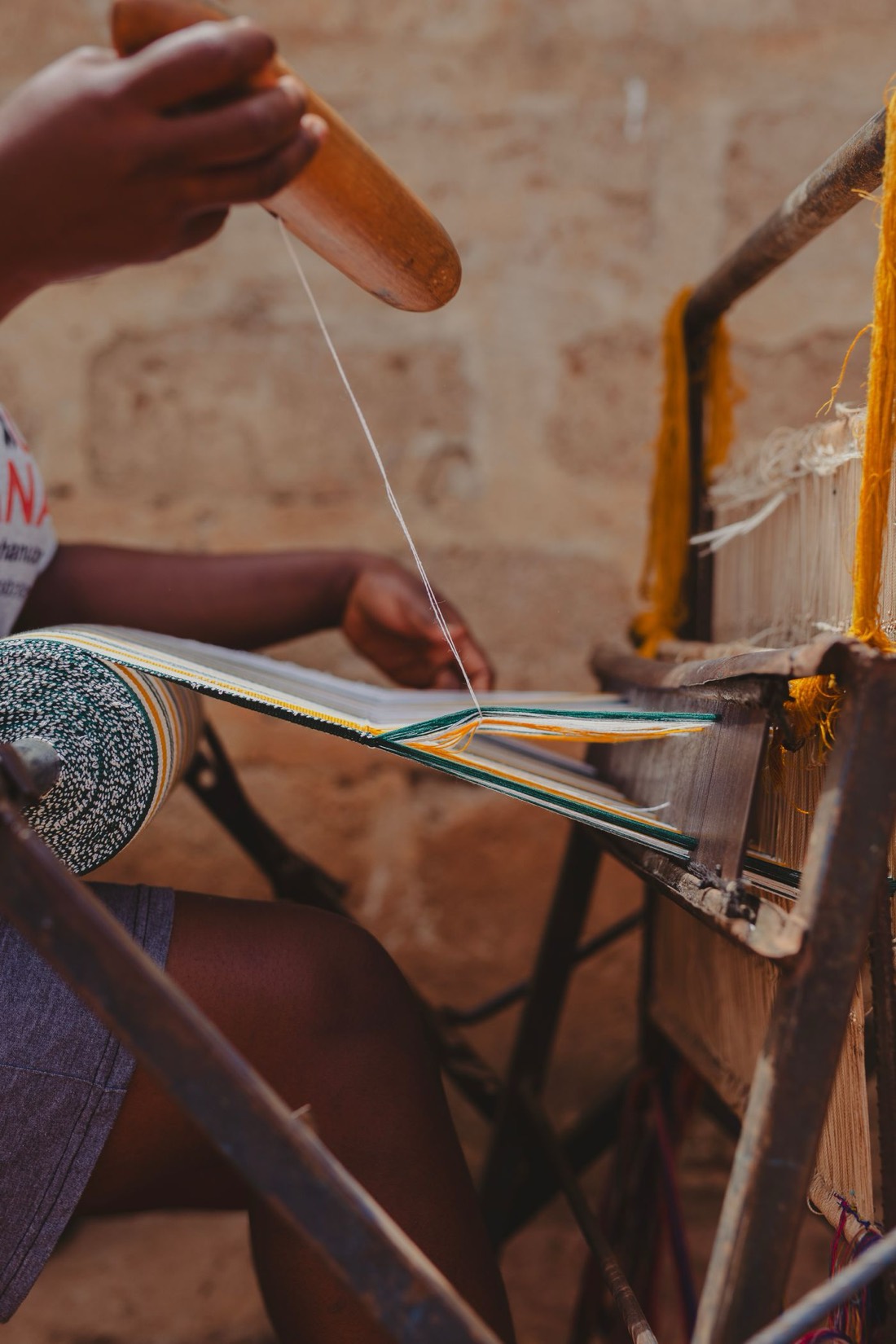 Hands weaving kente at the loom, heritage in the making